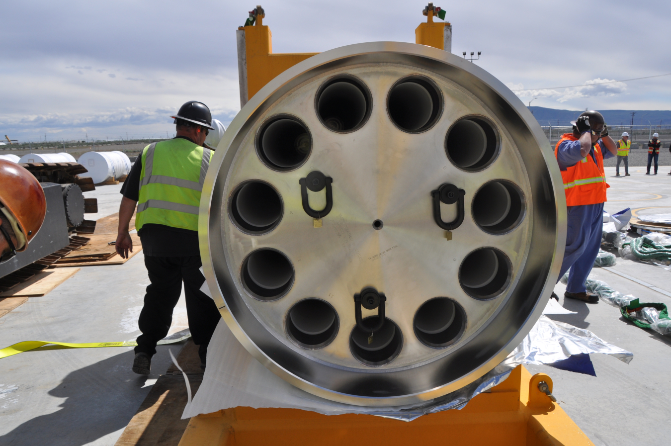 A large circular capsule with lots of smaller black holes throughout the edges of the bottom of the machine