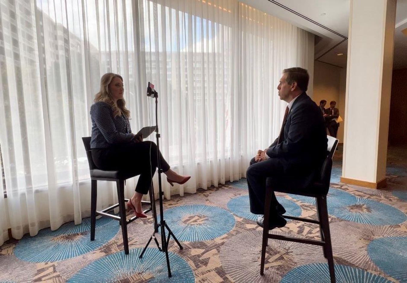 Two people sit in chairs and talk to each other during an interview