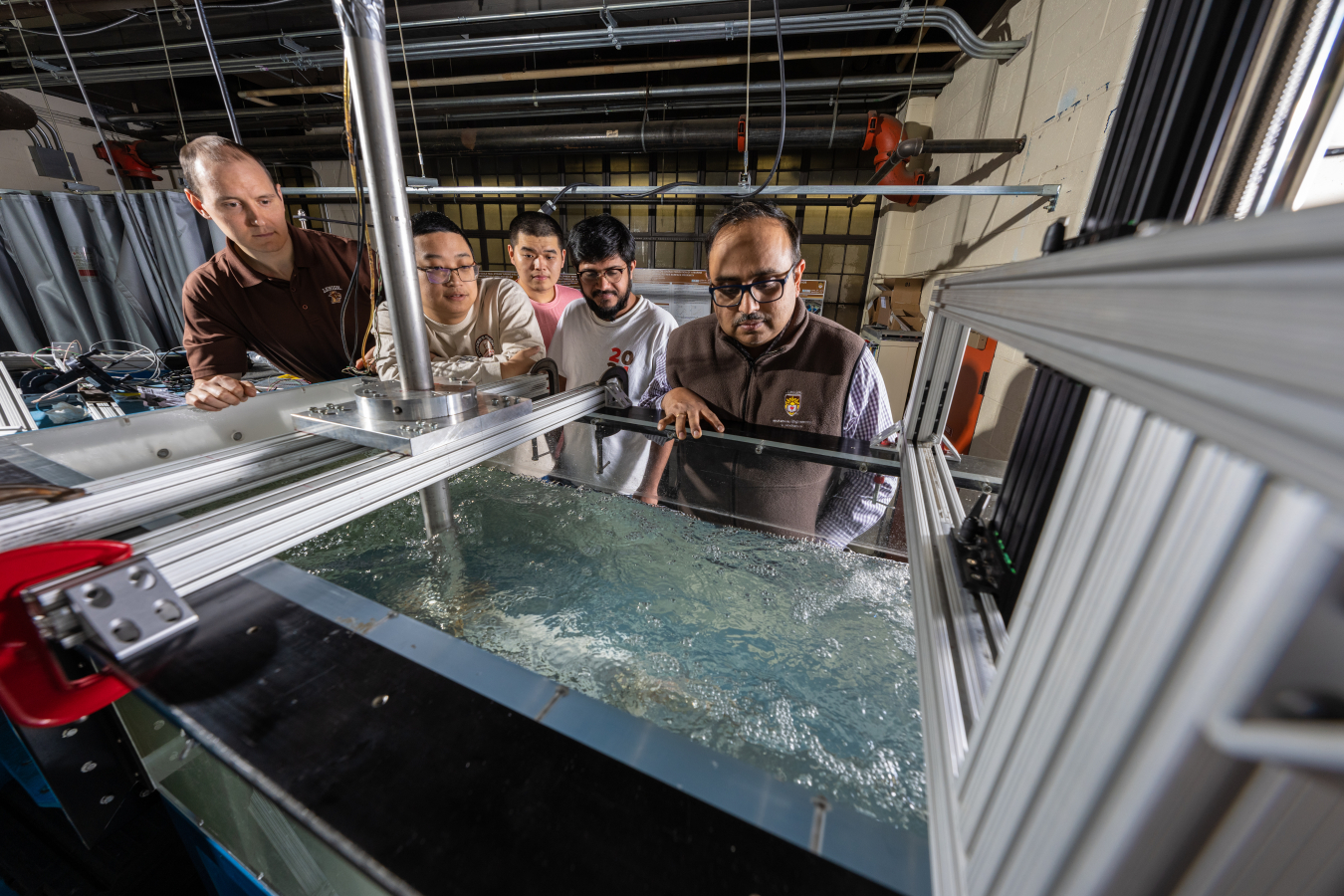Christopher Ruhl looks over a water tank in a lab setting