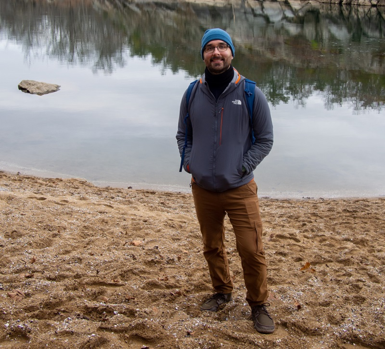Jake Herb standing on a beach in front of a river