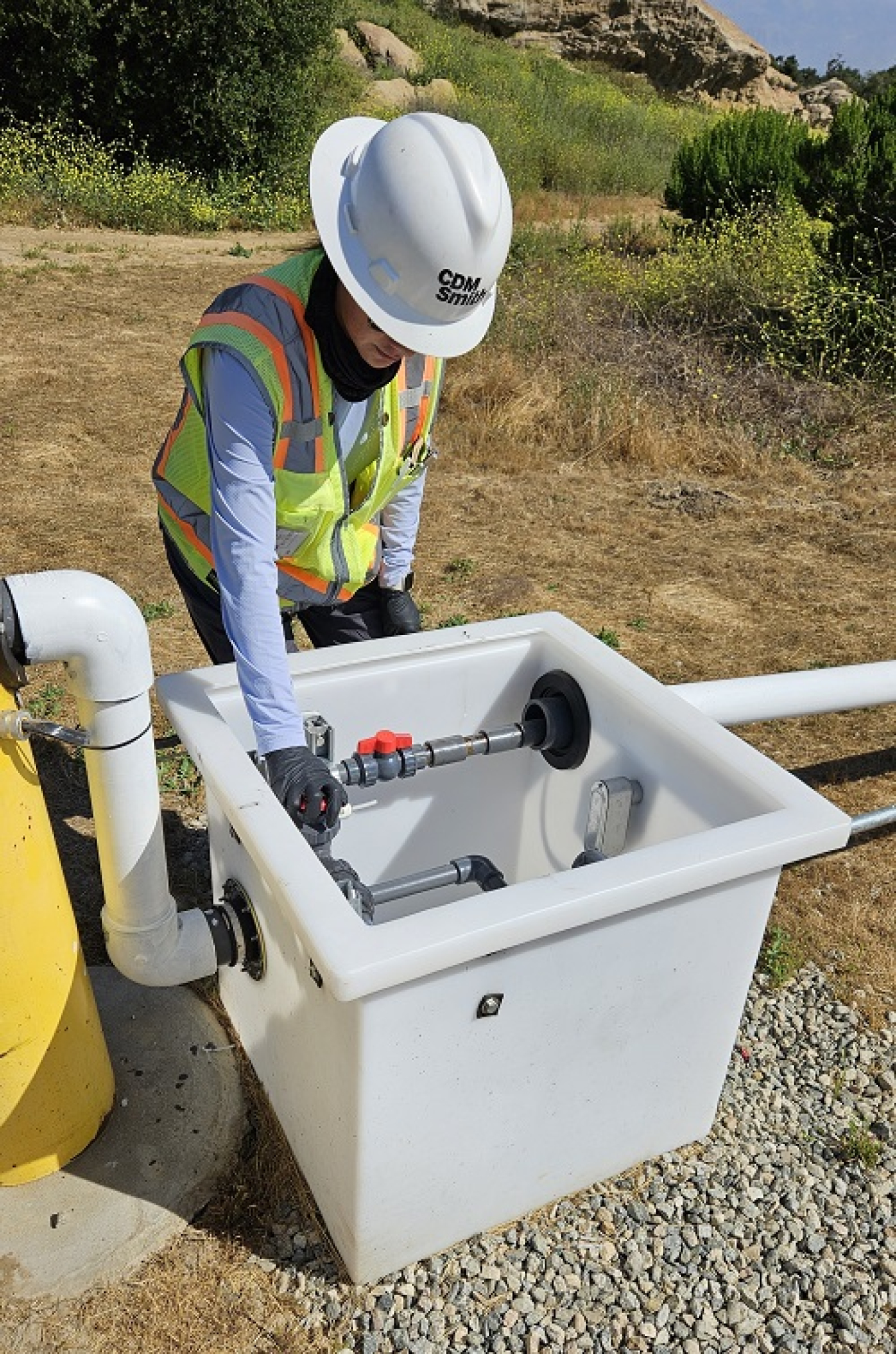 A person adjusts the control valve for automated groundwater extraction well C-24 in Area IV at Santa Susana Field Laboratory.