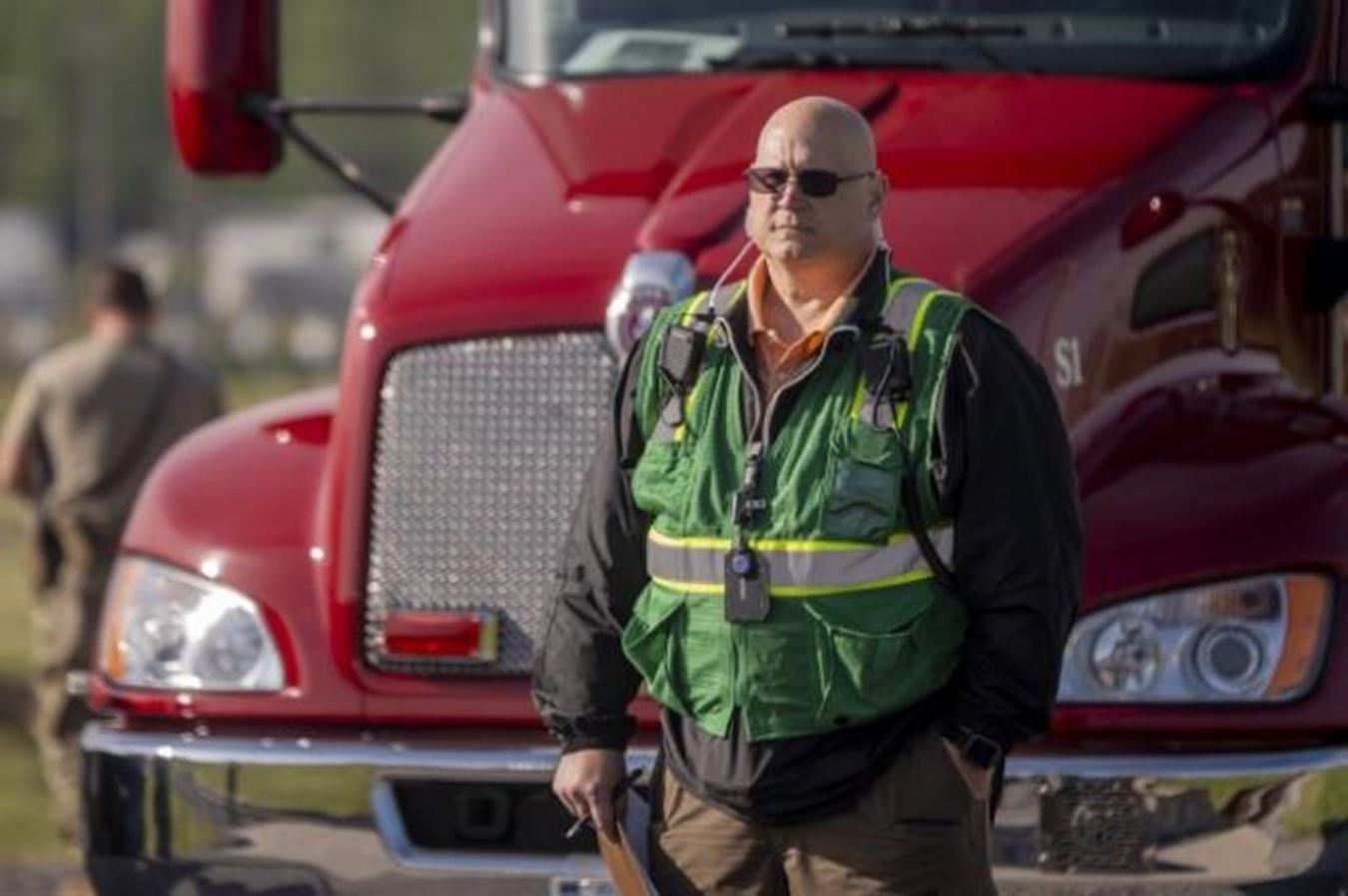 Scott Baird wearing safety vest standing in front of semi truck
