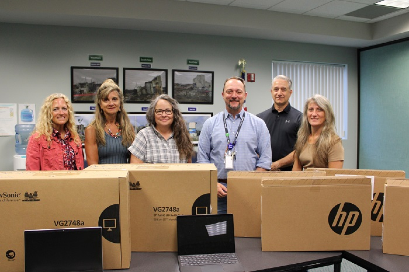 People stand behind newly purchased electronic equipment.