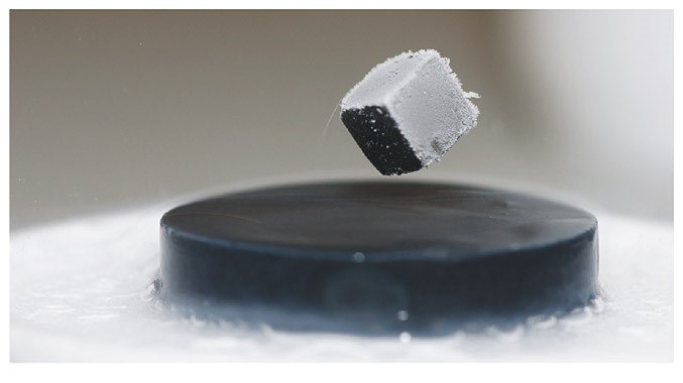 A cube of magnetic material levitates above a superconductor. The field of the magnet induces currents in the superconductor that generate an equal and opposite field, exactly balancing the gravitational force on the cube.