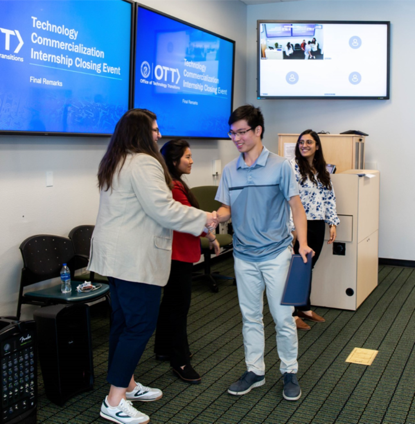 Intern Kelvin Wang receiving graduation certificate from OTT program leads at the internship closing event.