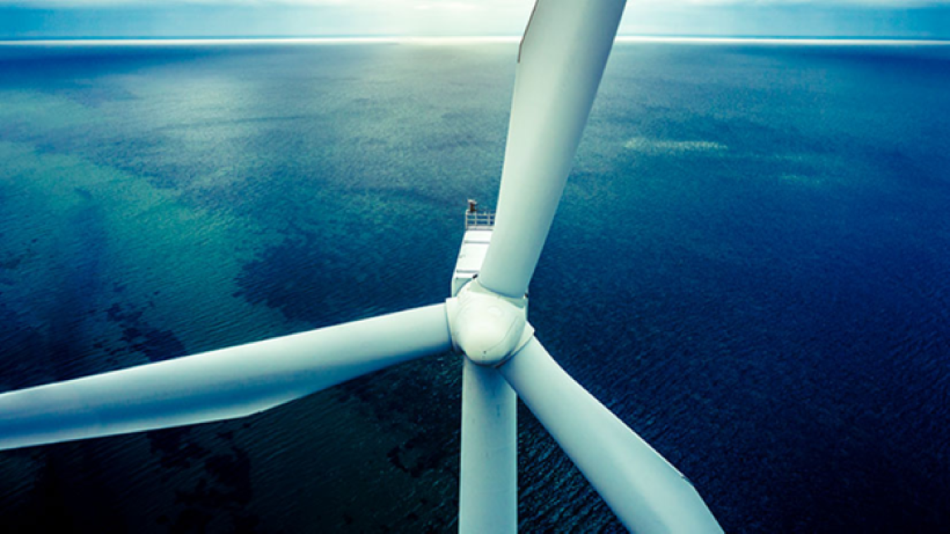 Aerial view of a wind turbine above a waterway.