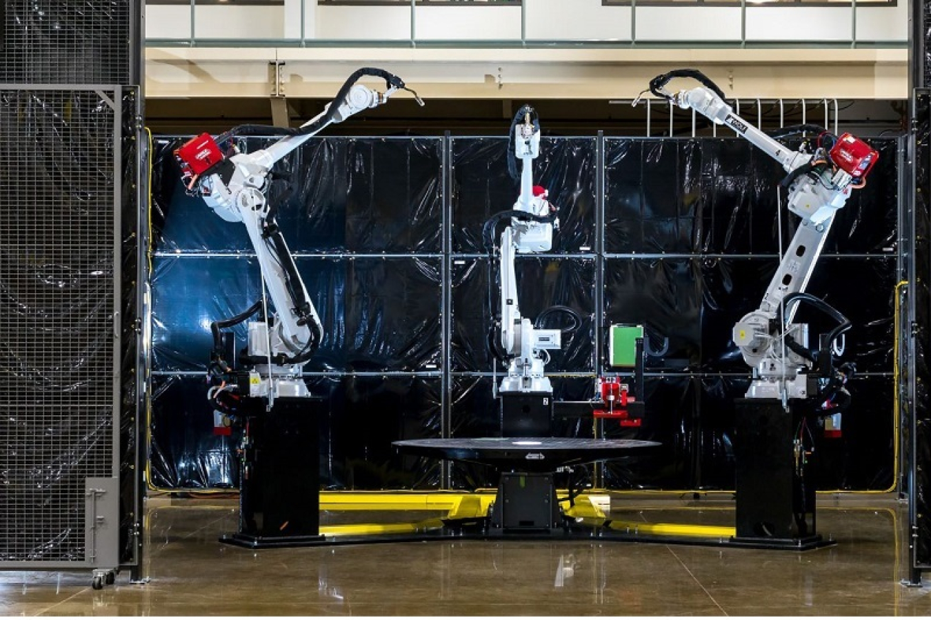 Three robot arms centered around a small table at DOE's Manufacturing Demonstration Facility at ORNL