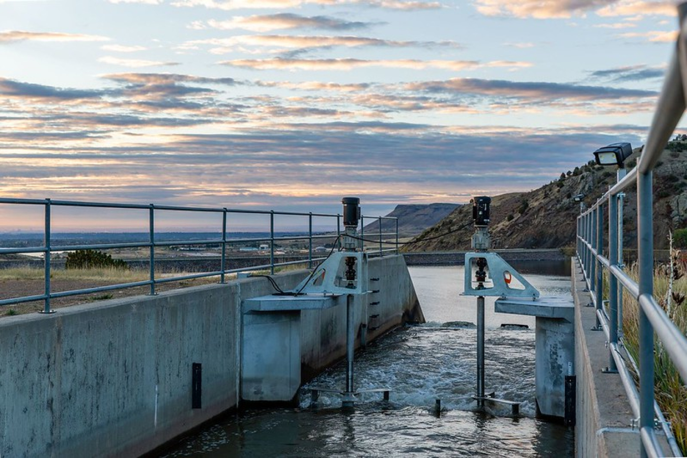 Cloudy sunset and rocky hills behind Emrgy's distributed hydropower project in Colorado.