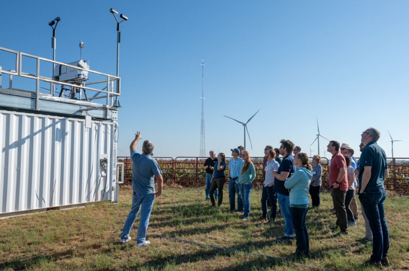 People stand outside reviewing a wind farm experiment