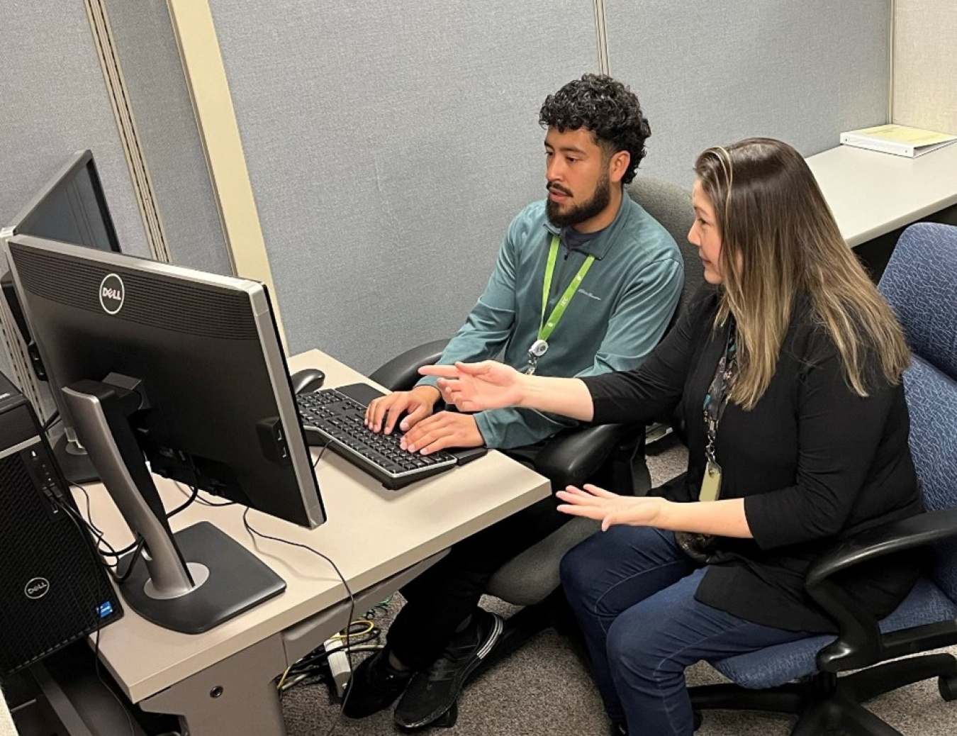 An intern and advisor sit and a computer and work together
