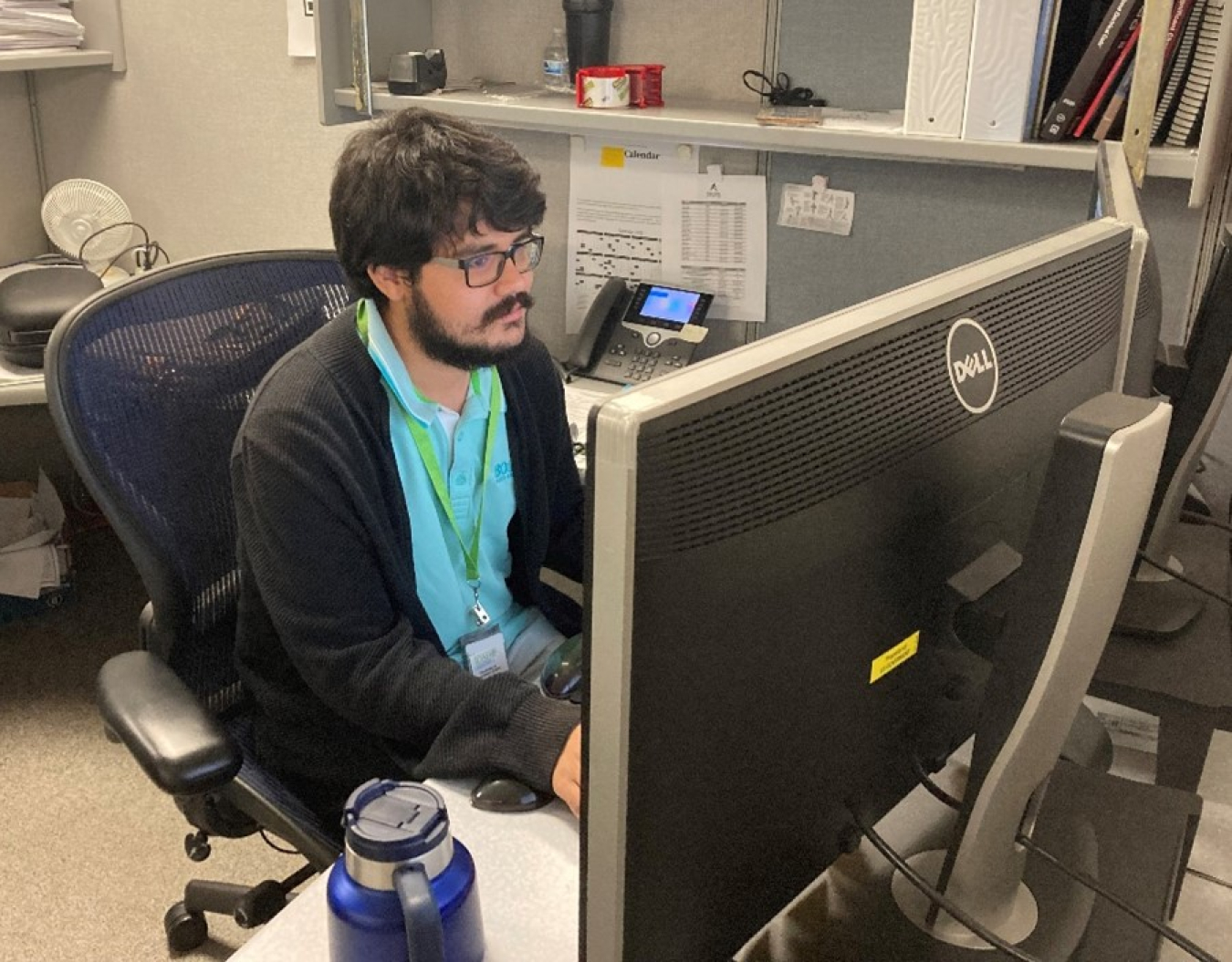 An intern sits at a computer and works