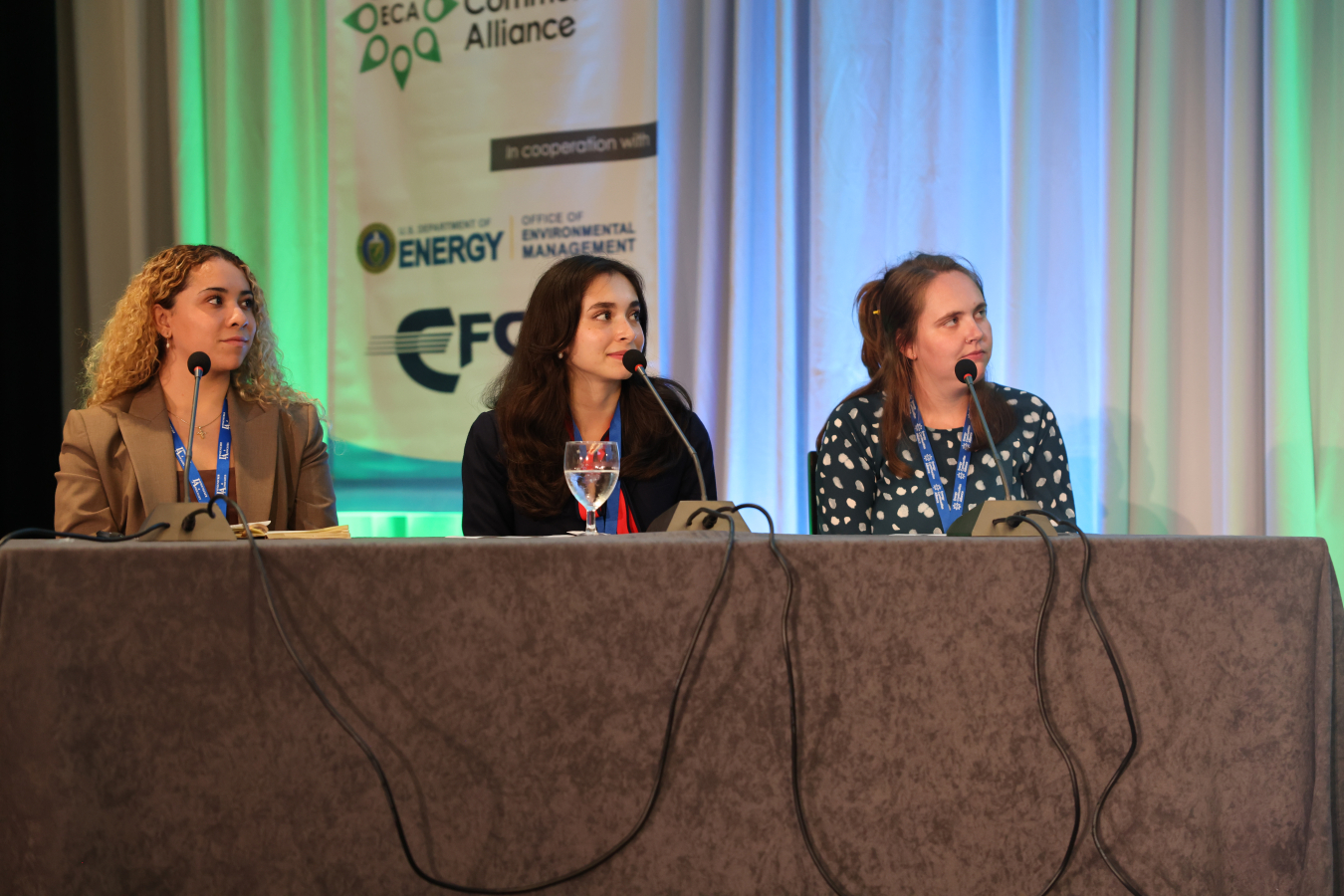 Three young professionals participate in a panel at a conference