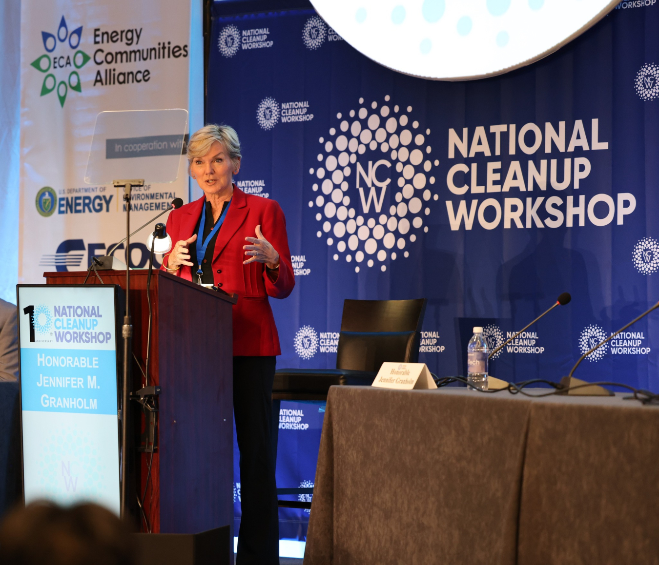 The Secretary of Energy stands on a stage behind a podium and speaks to the audience