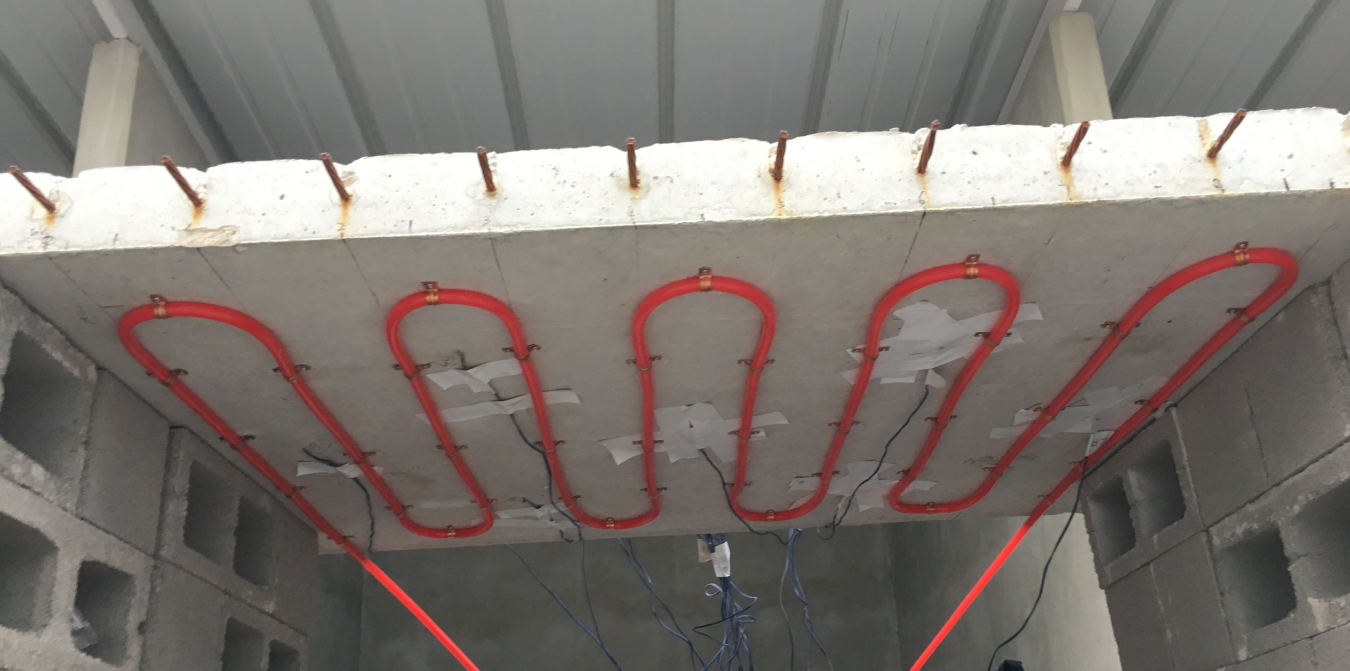 Tubes loop back and forth on a surface beneath a bridge.