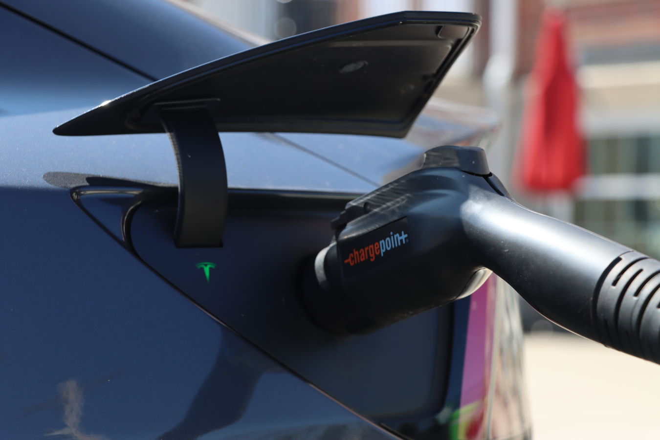 Up close view of an electric vehicle charger plugged into an electric vehicle