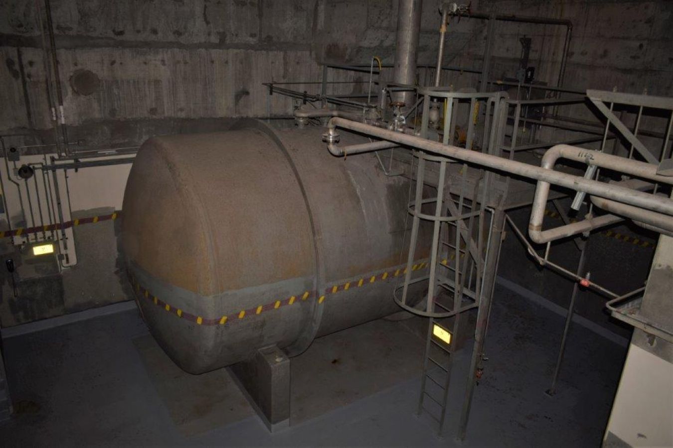 A large, rusted, underground tank