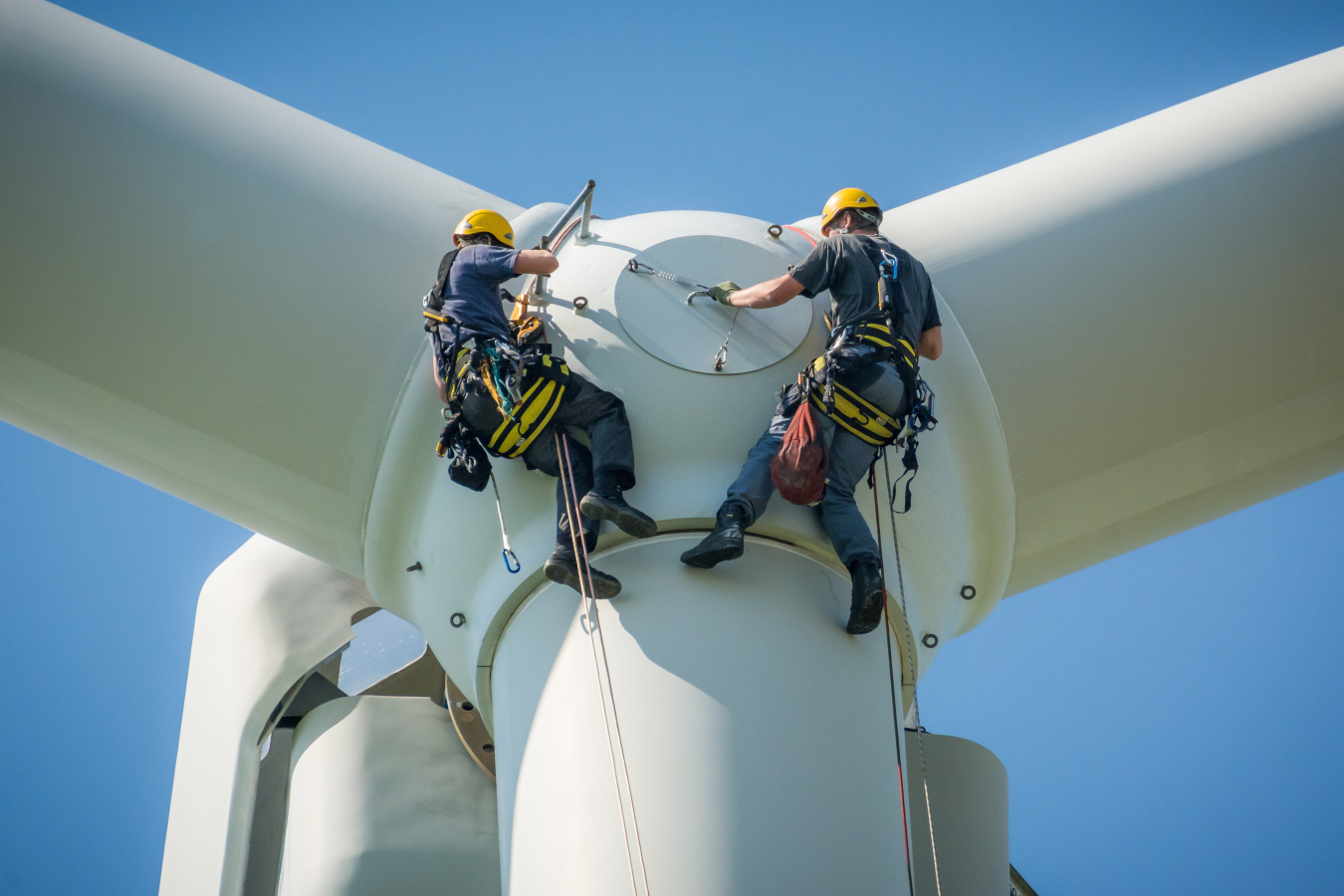 Two workers climbing a wind turbine