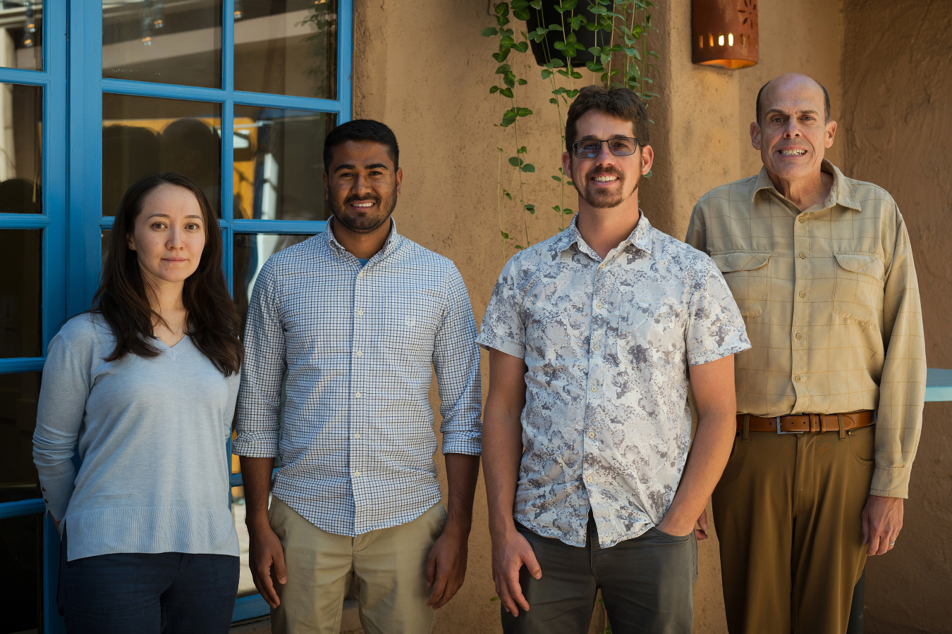 Four people pose and smile for the camera.
