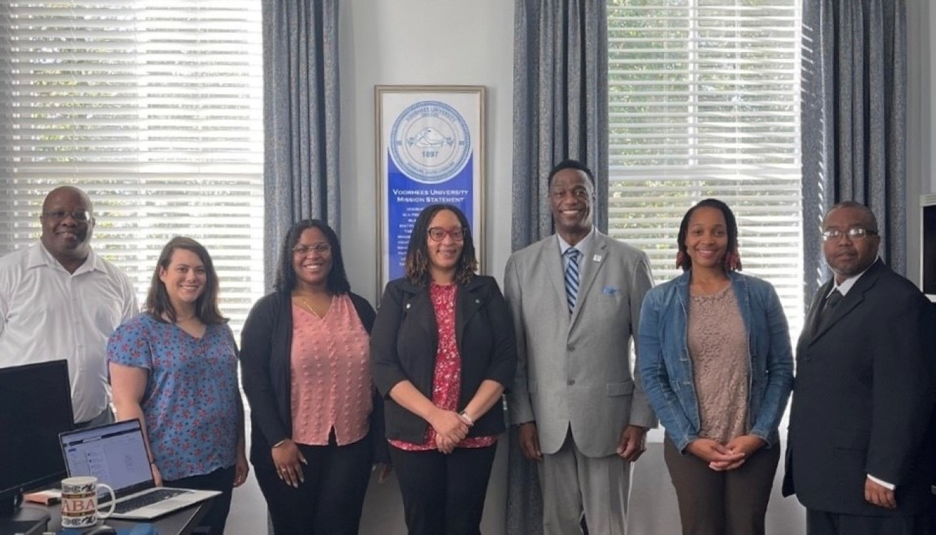 A group of professionals pose for a picture in an office