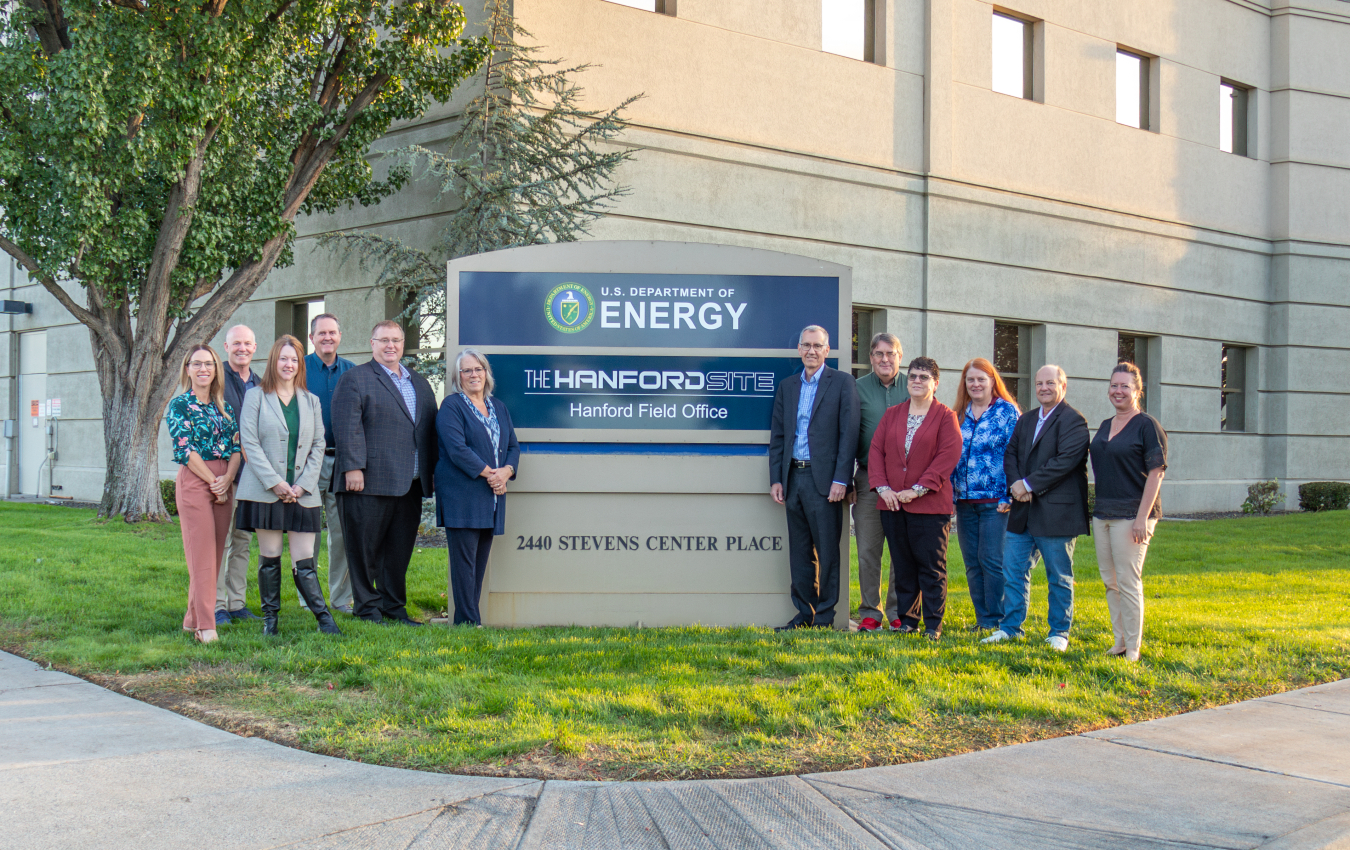 People standing with new Hanford sign with Hanford Field Office