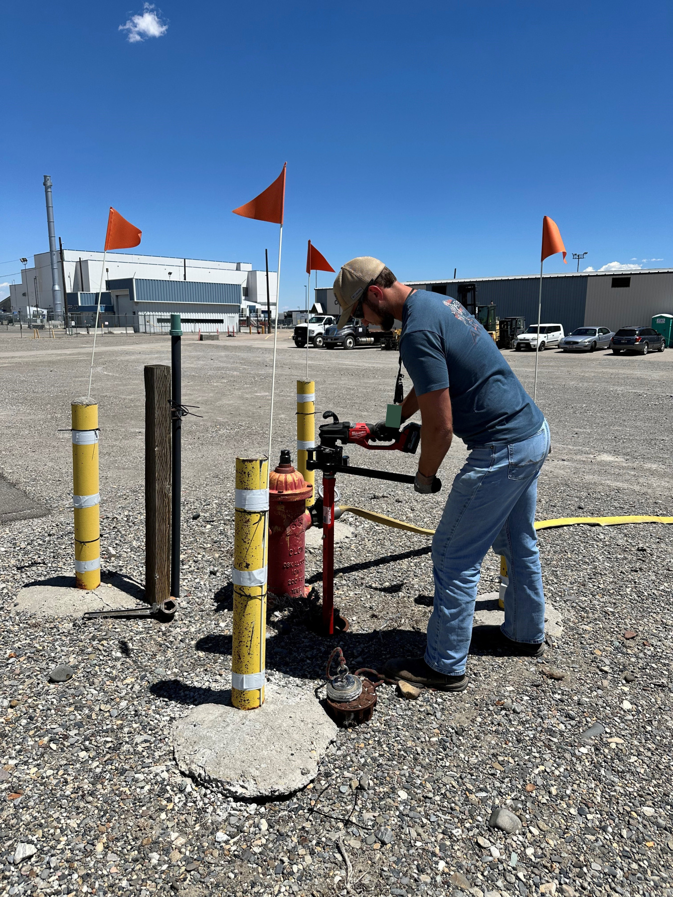 A man works on a pump coming out from the ground outside