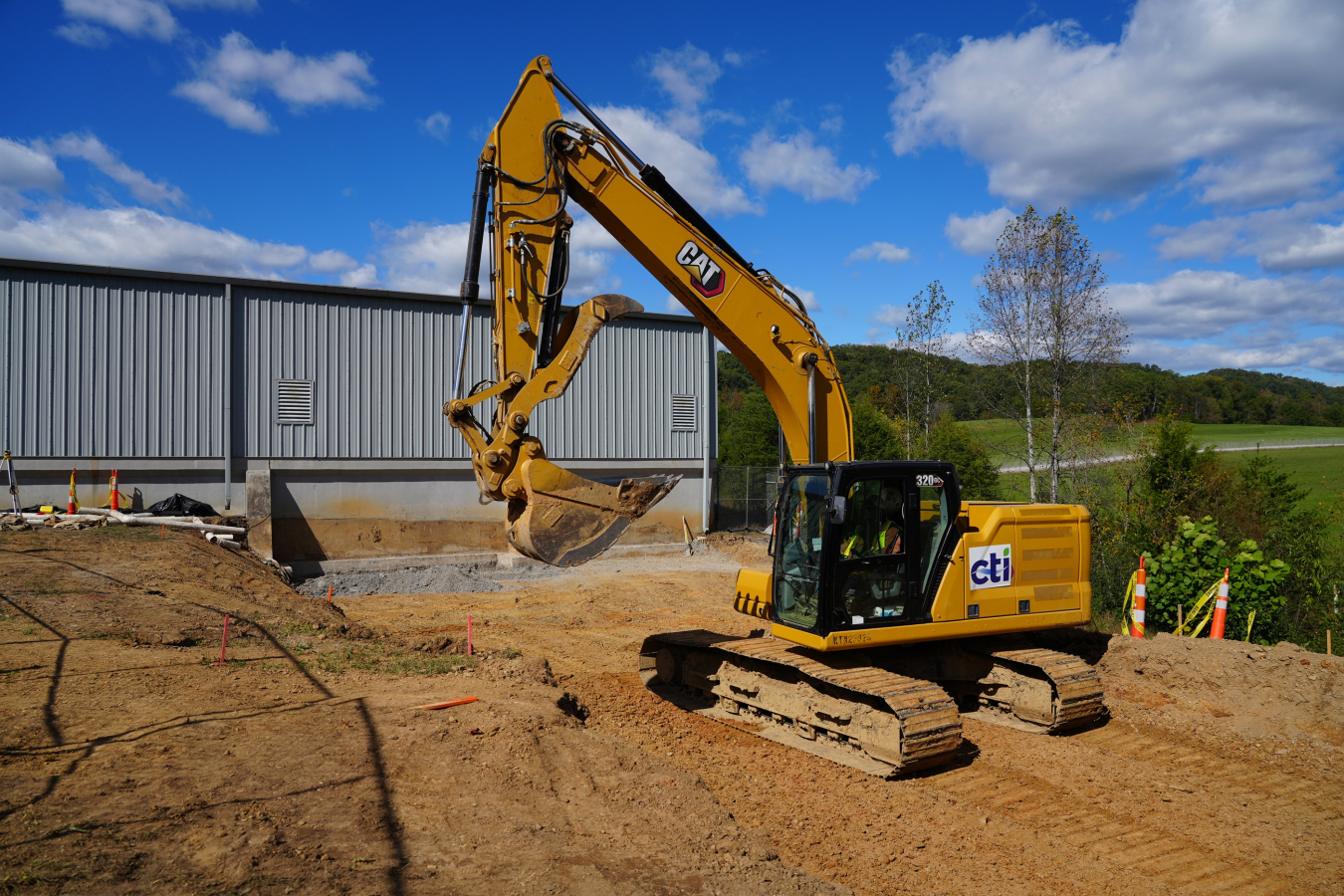 A yellow work machine vehicle operates and moves some dirt