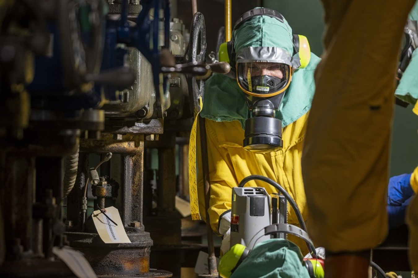 A deactivation crew maintenance mechanic positions a core drill for sampling of piping for storage tanks in the C-333 Process Building.