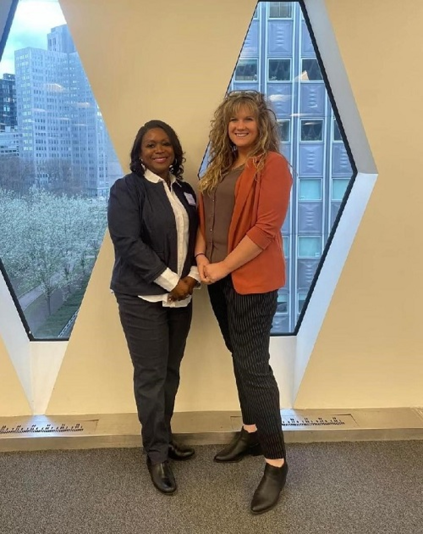 Two women stand side by side and pose for a picture