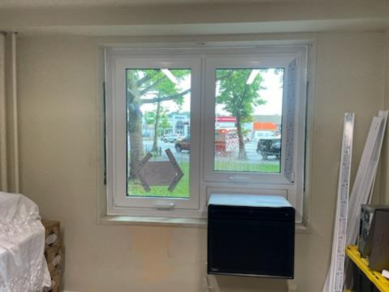 A window with a heat pump at the bottom. The inside view is inside a room