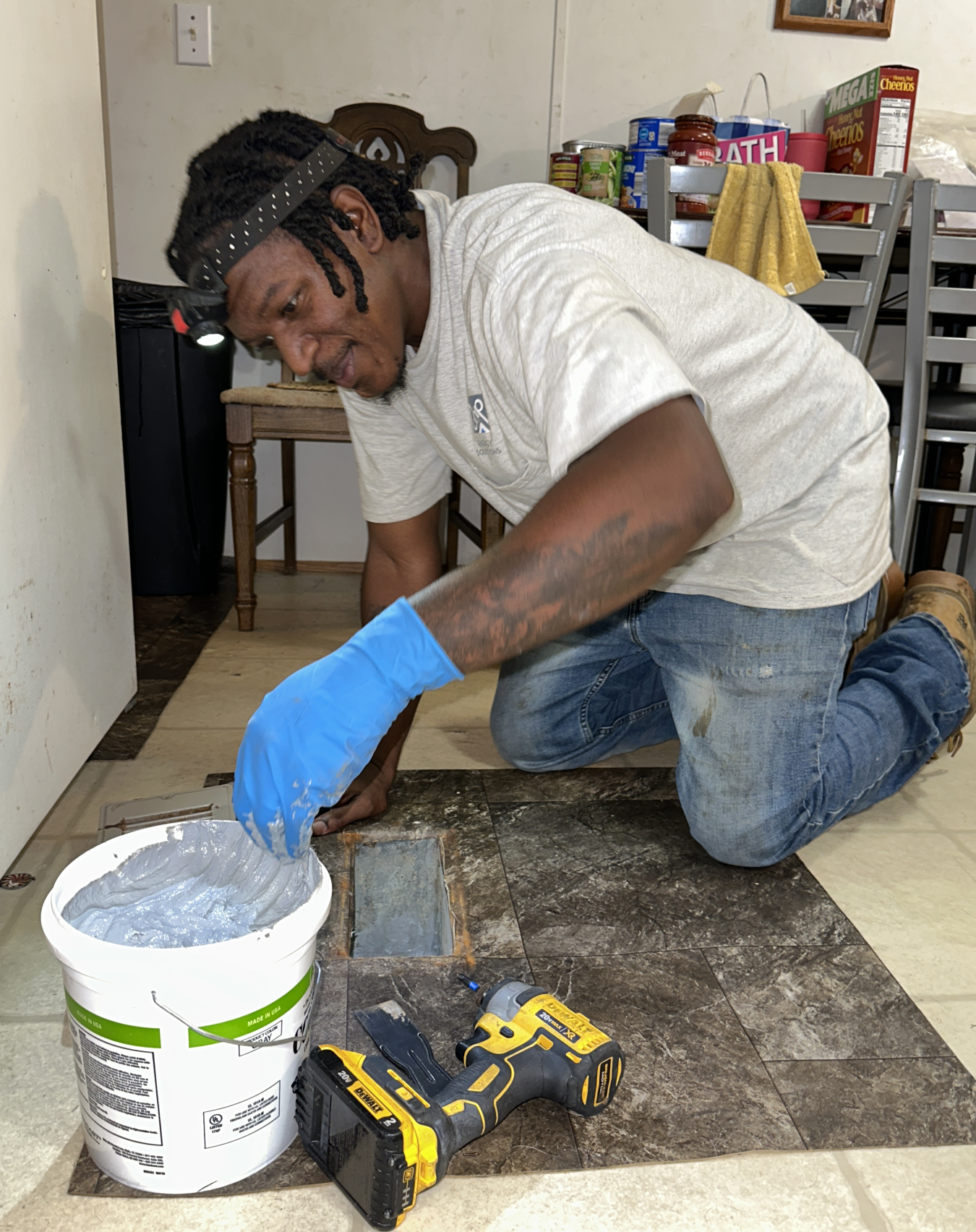 A person works on a duct on the floor of a mobile home.