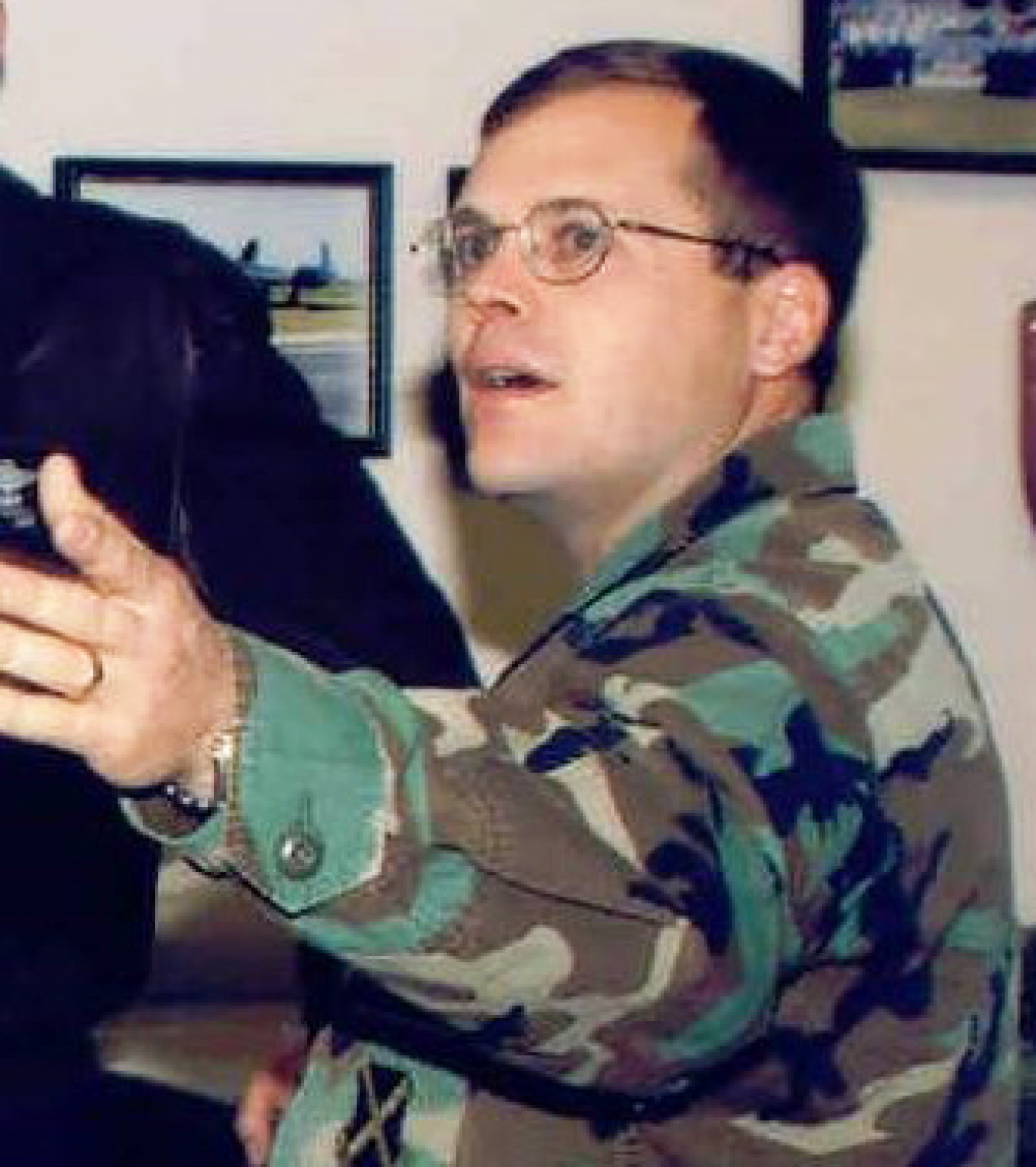 A man in a military uniform gestures.