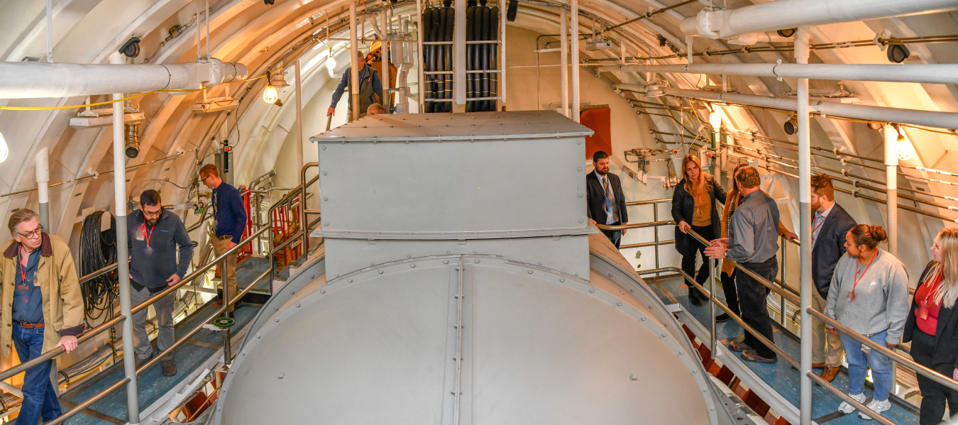A group of people touring the inside of a naval reactor