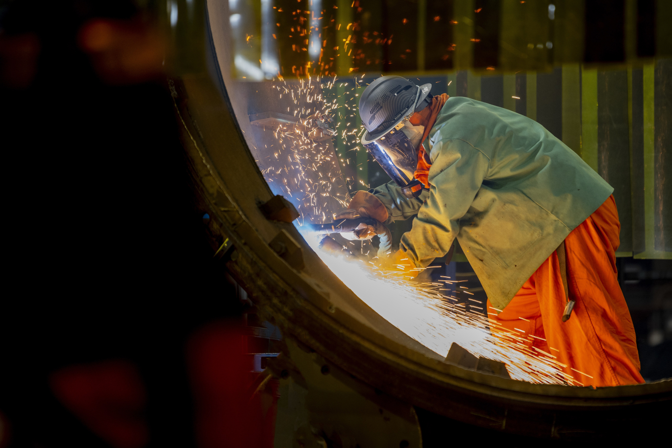Sparks flying as a person uses a tool on a metal pipe. 
