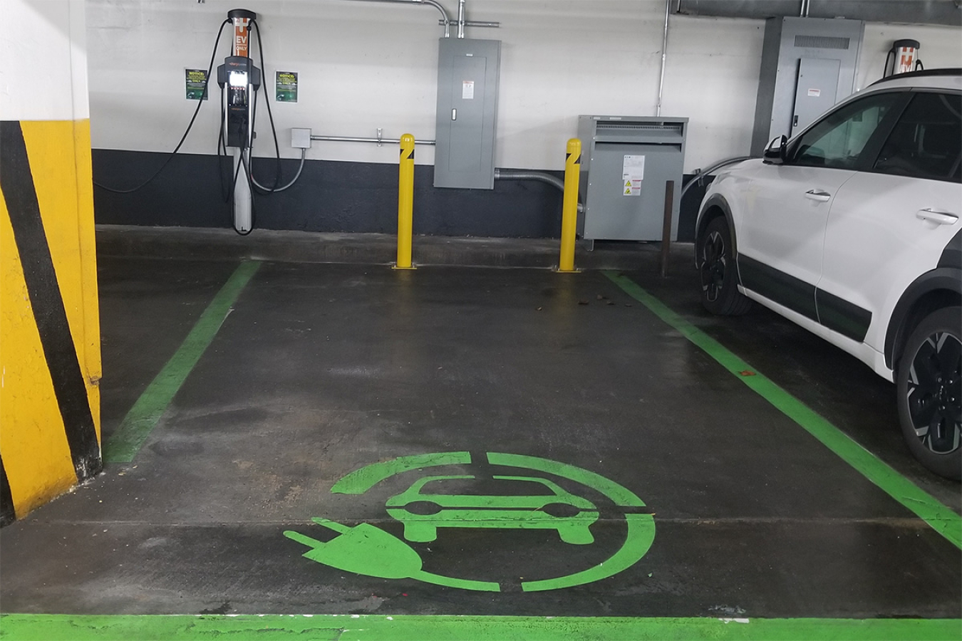 A designated electric vehicle charging space in a parking garage.