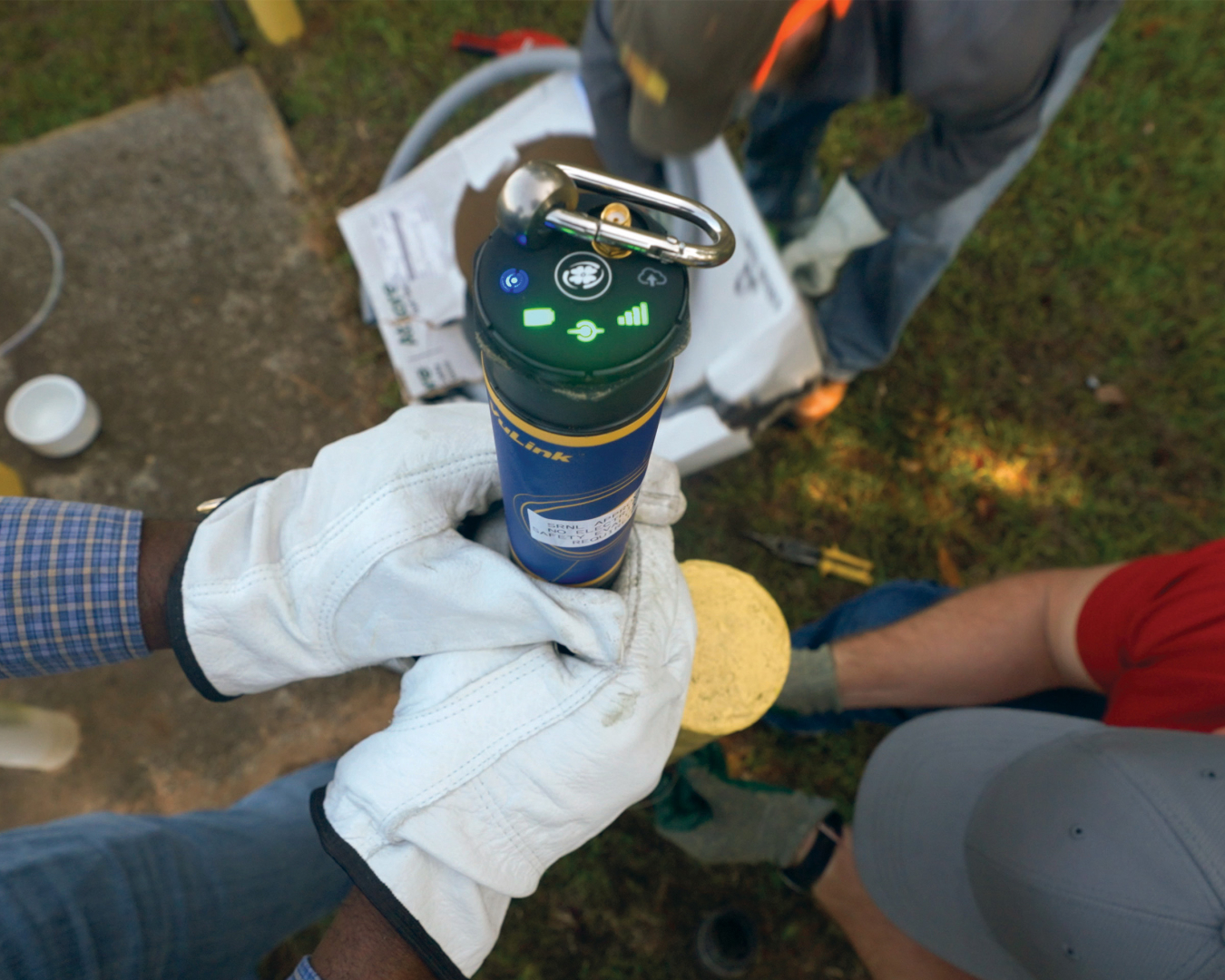 An up close view of a black monitoring device with green buttons on top 