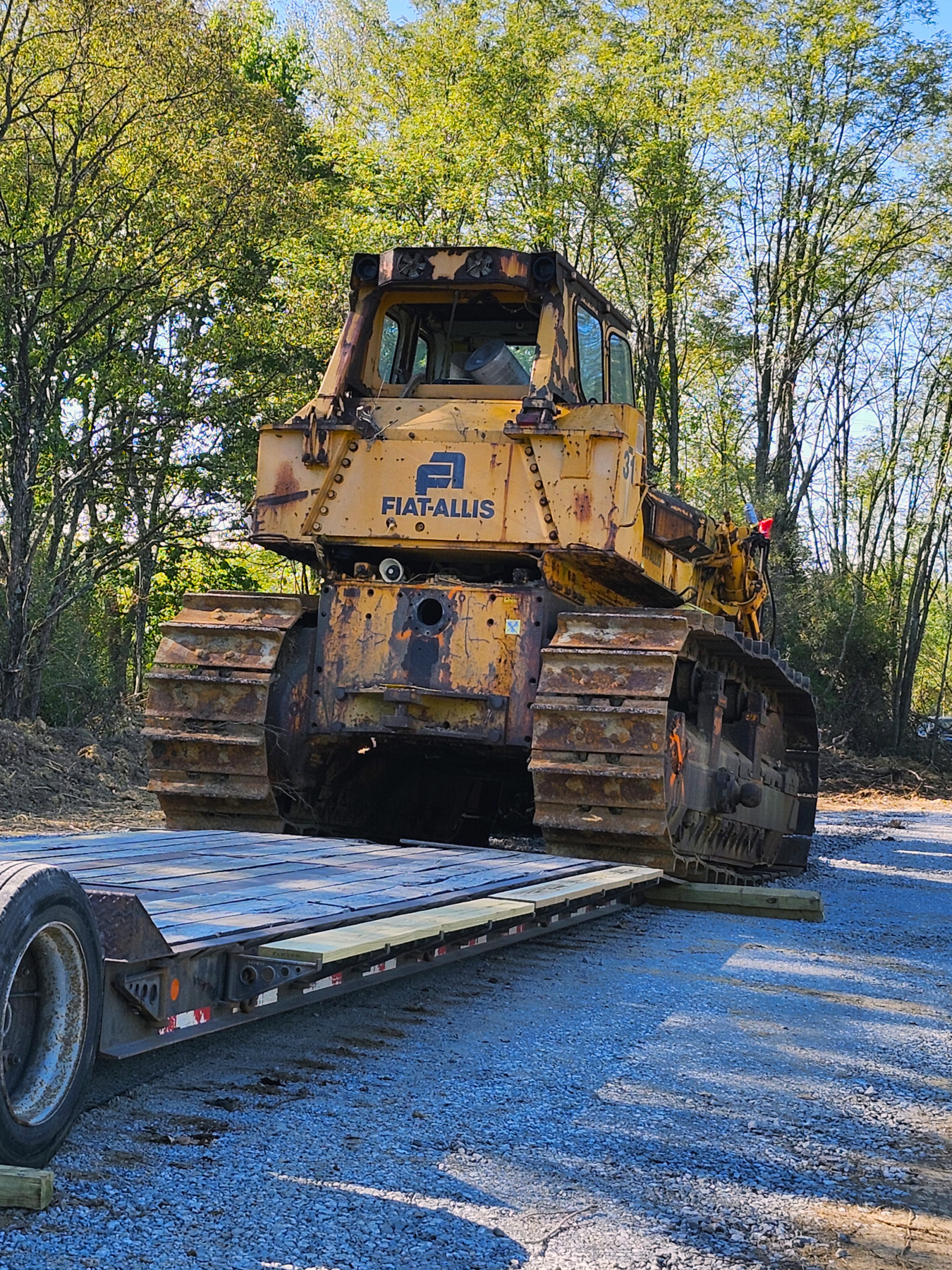 A work vehicle being loaded off of a flatbed trailer