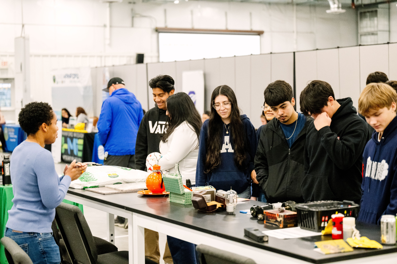 Students look at displays on table during a One Hanford STEM Day Career & Resource Fair.