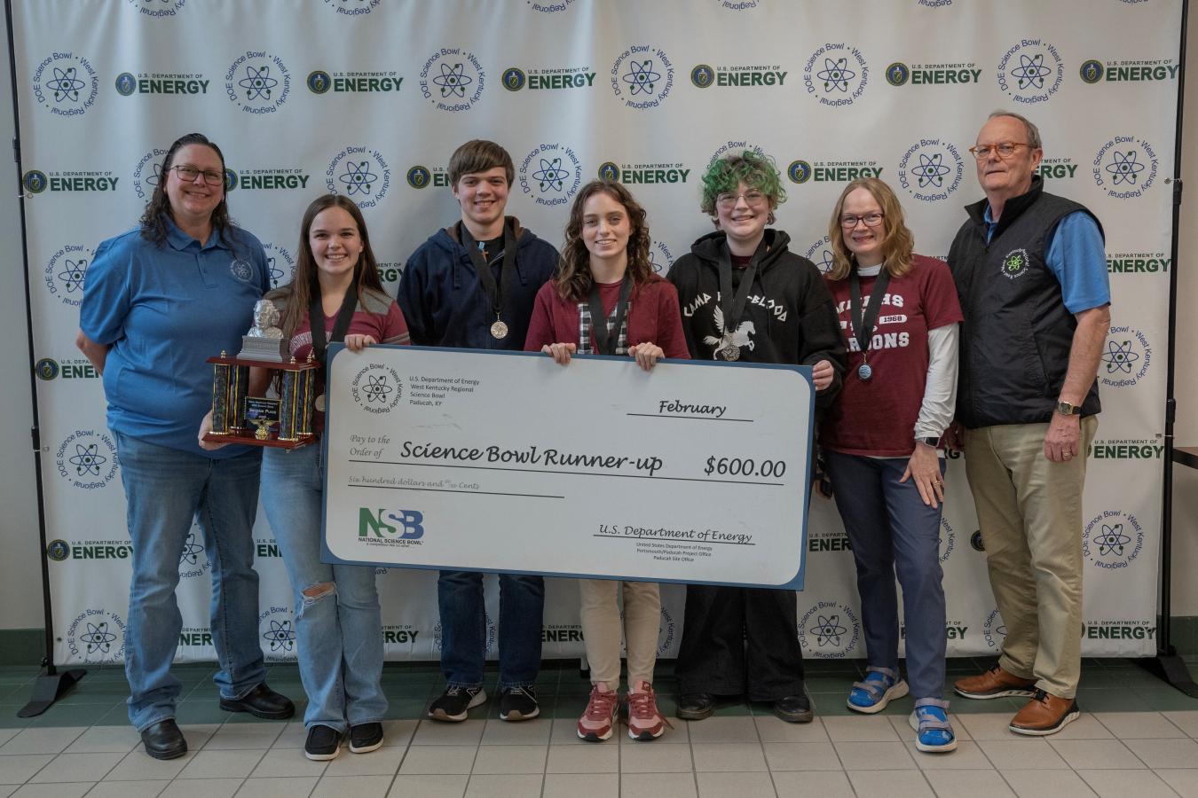 A group of students and coaches pose for a picture after placing in a science bowl competition