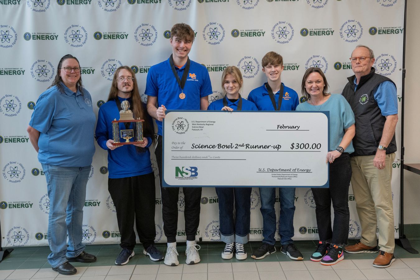 A group of students and coaches pose for a picture after placing in a science bowl competition