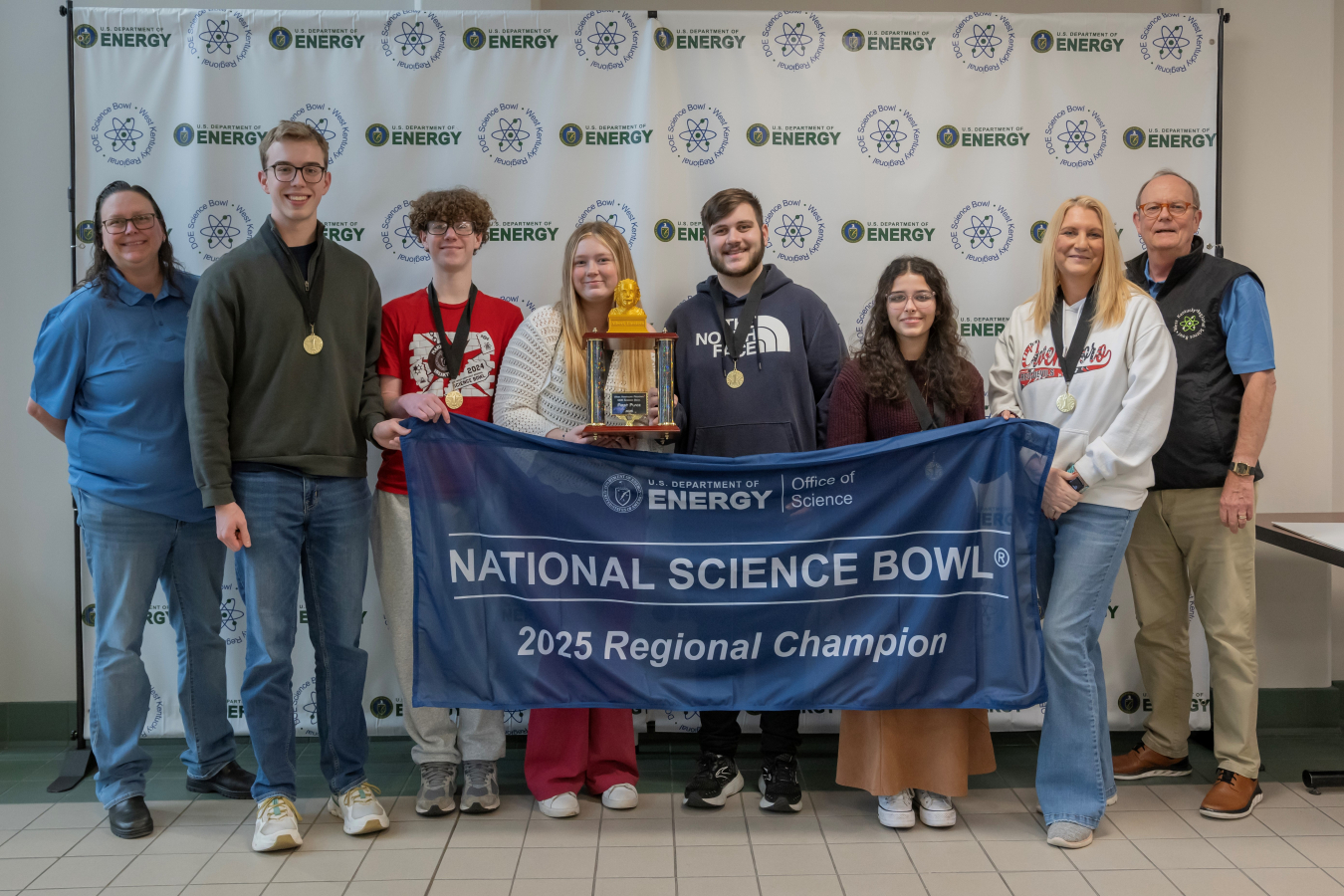 A group of students and coaches pose for a picture after placing in a science bowl competition
