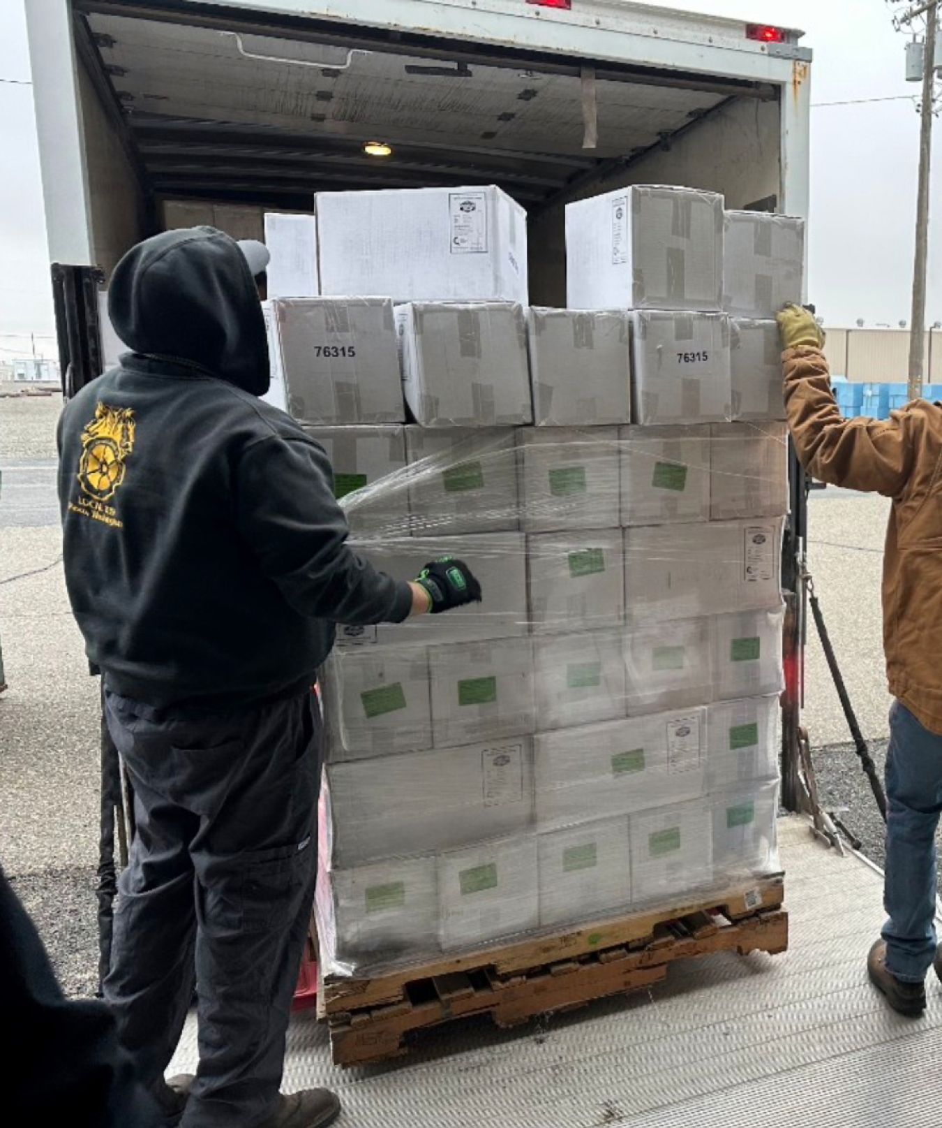 Employees standing by a case of protective equiptment