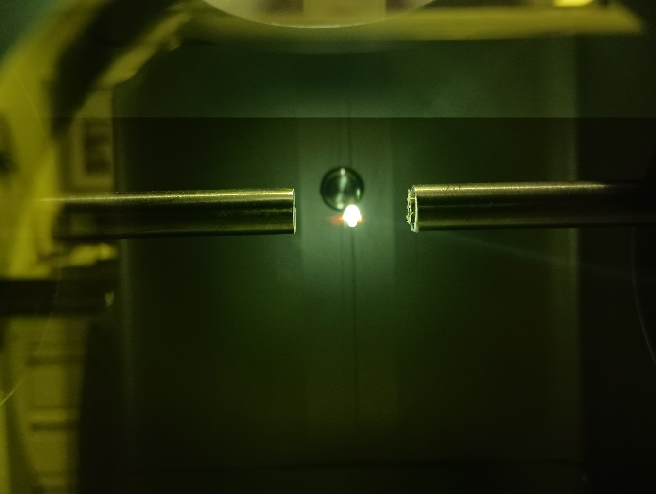 Dark green image with a point of light from a laser in the center
