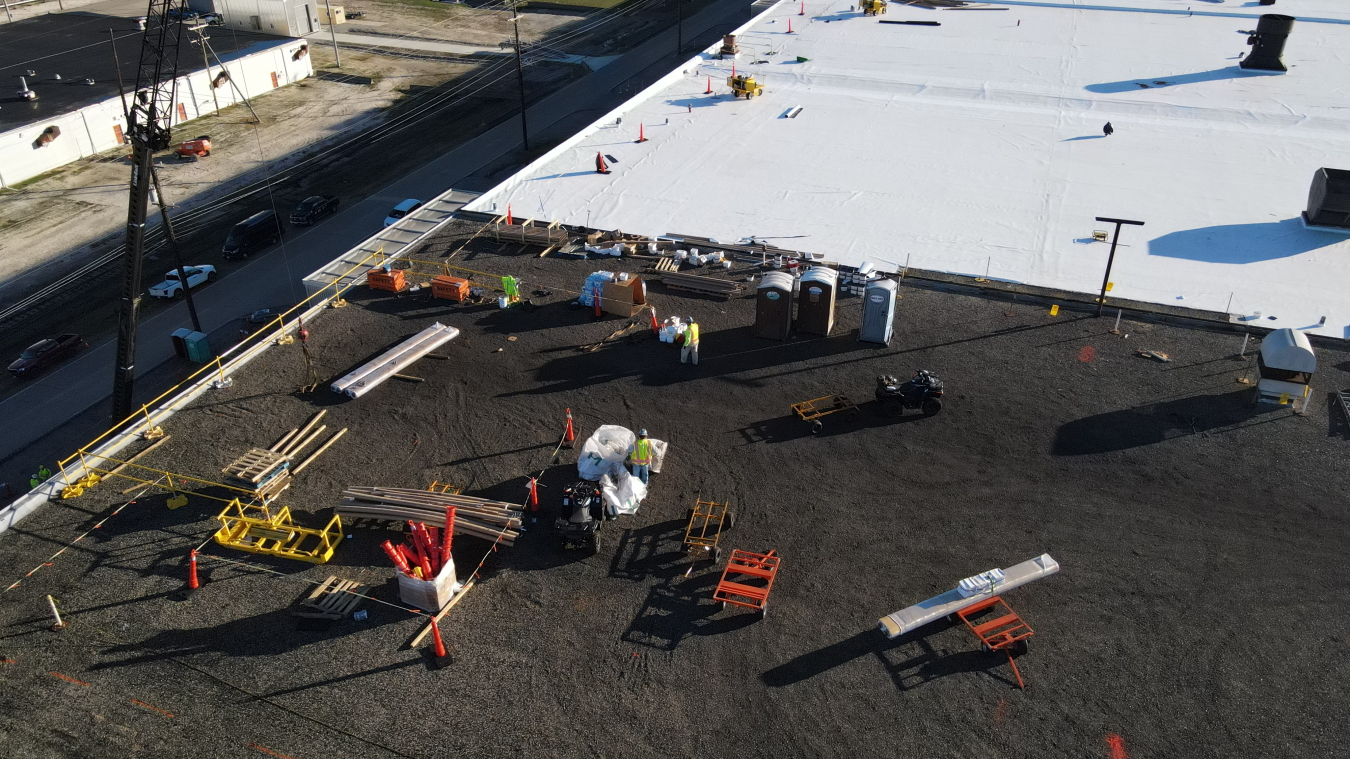 Crews carrying out repairs on the roof of a large building