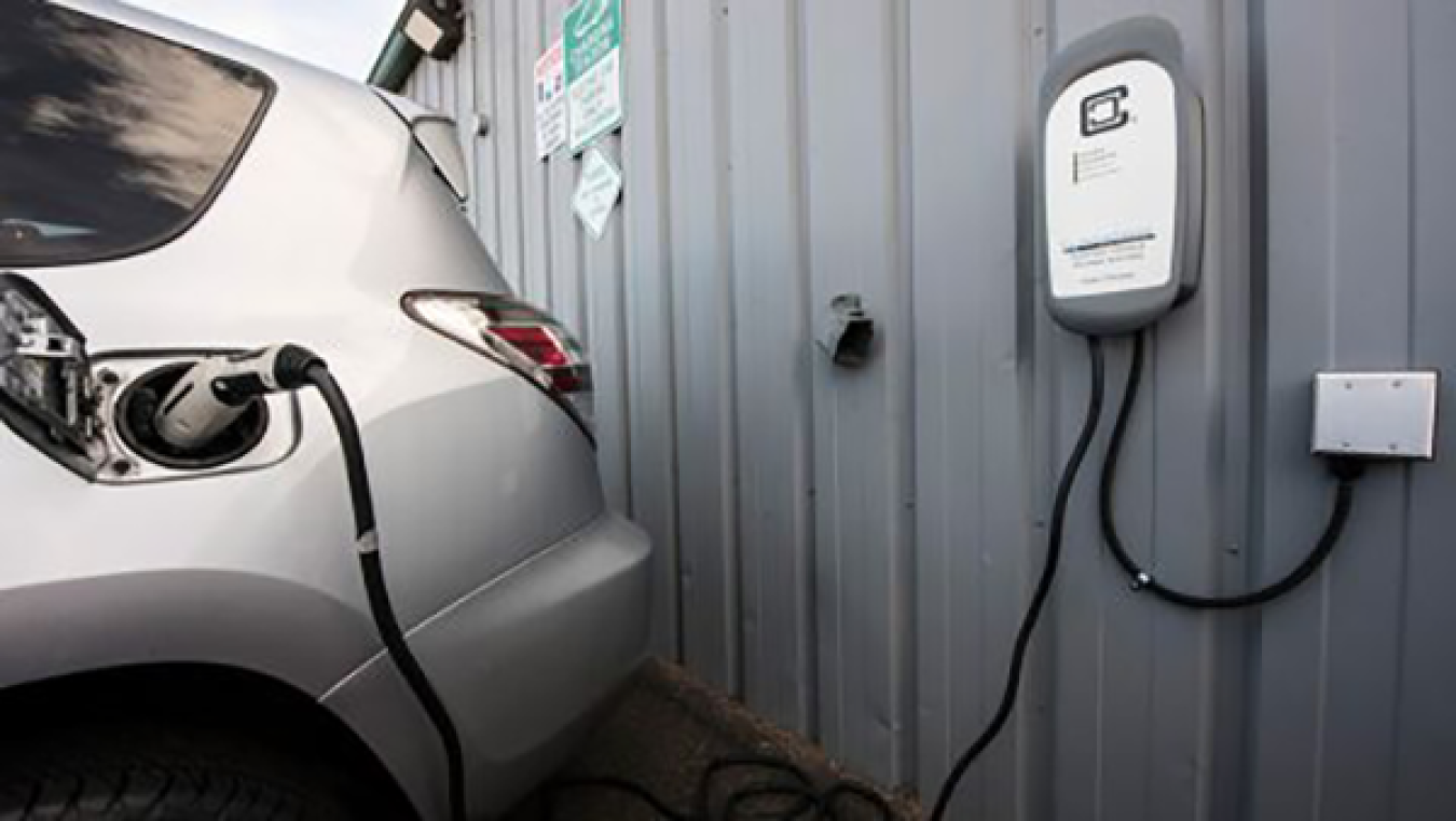 Electric vehicle parked and charging at a charging station