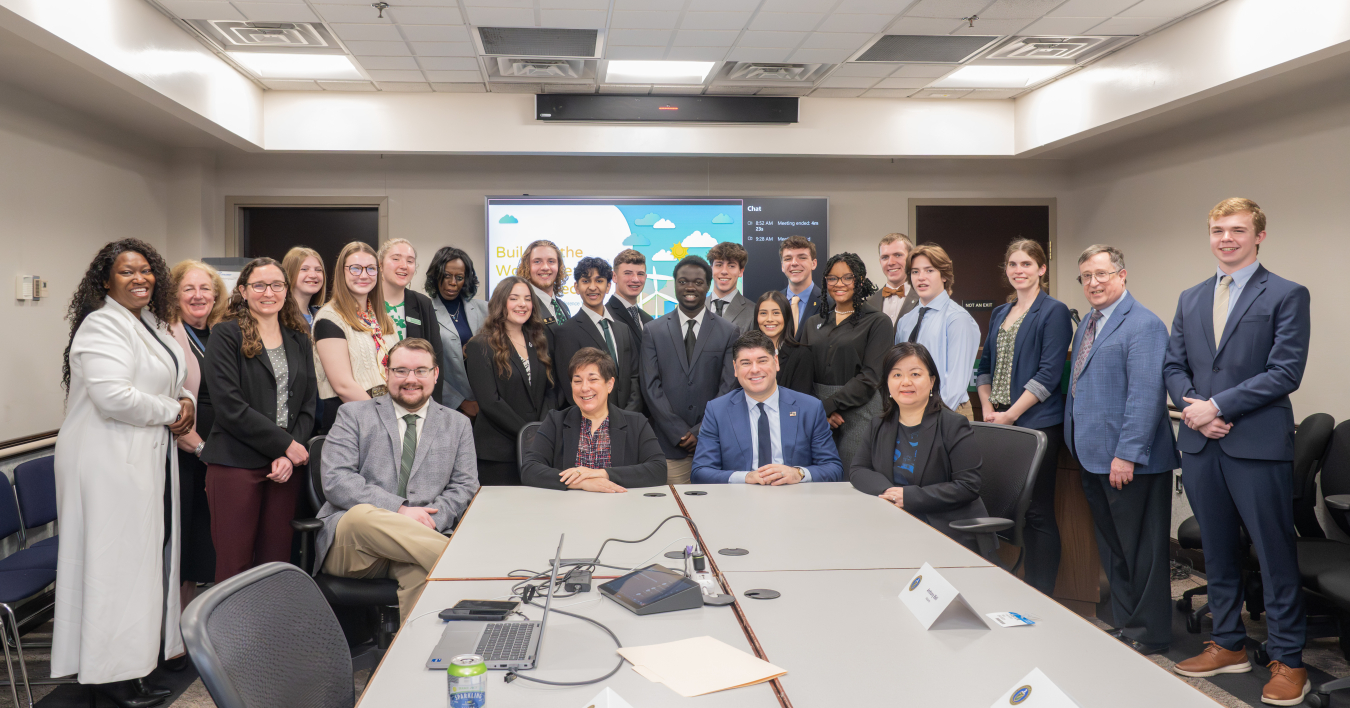 A group of 4-H students from the 2025 National 4-H Conference stand with and behind DOE officials.