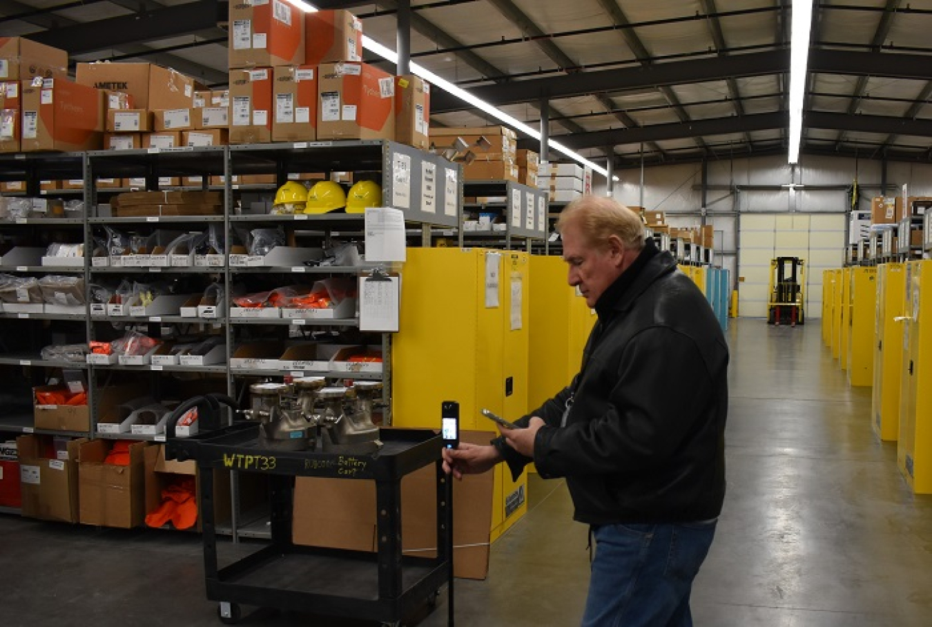 A man sets up a special 360-degree camera inside a plant warehouse.