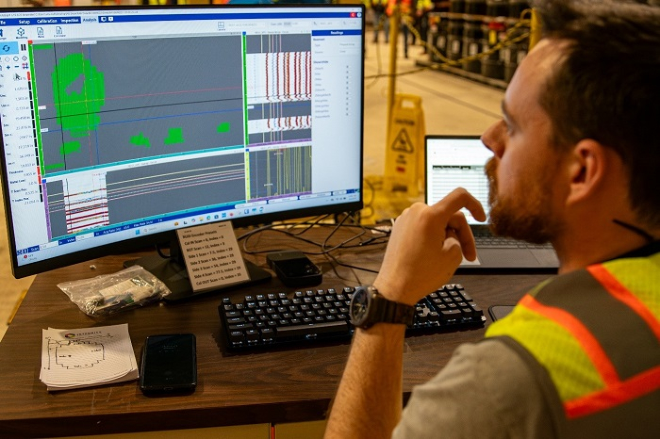 An employee monitors a demonstration on a computer screen to ensure transuranic waste drum integrity..