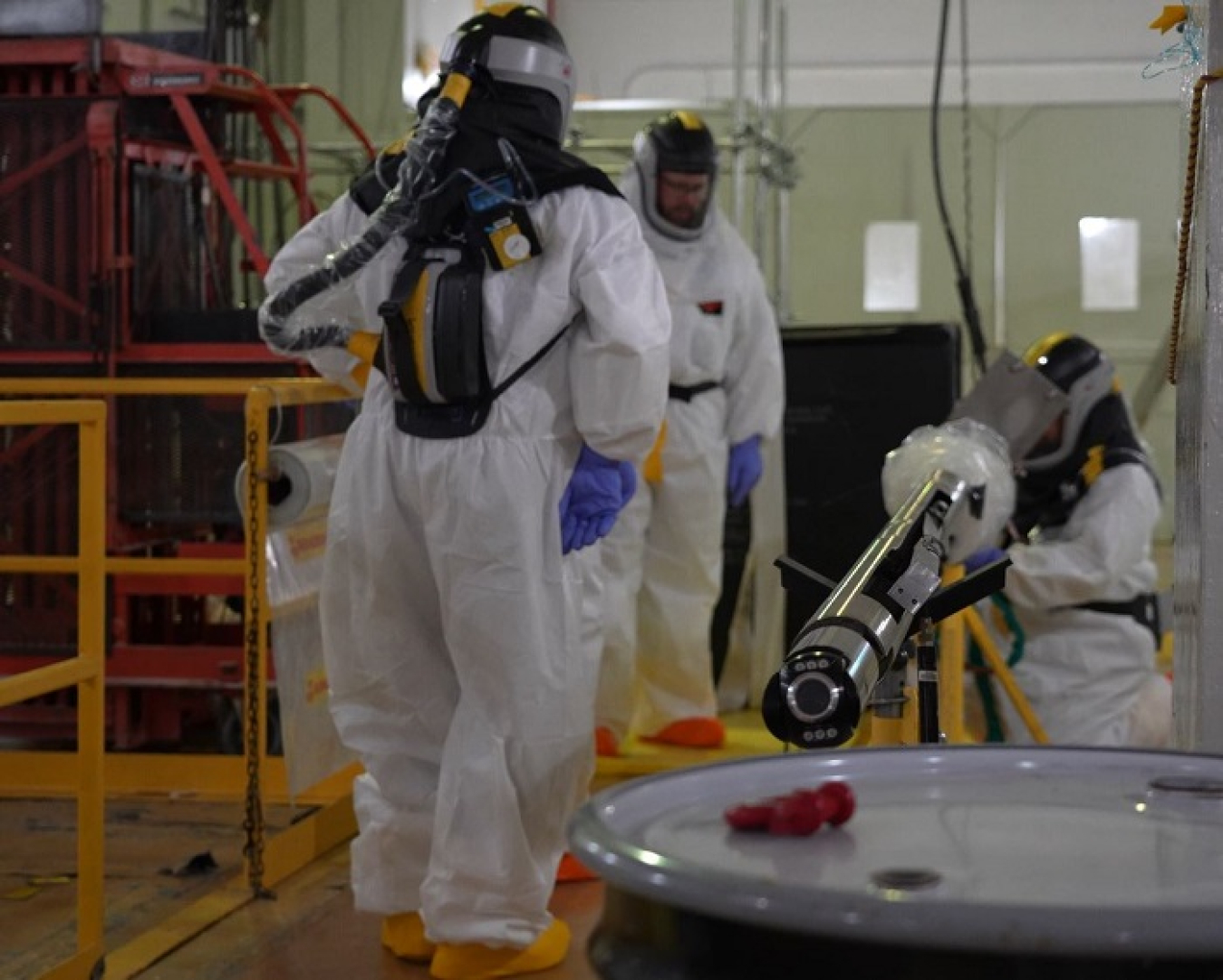 Workers set up equipment to remotely enter the hot cells to gather video footage and radiological surveys.