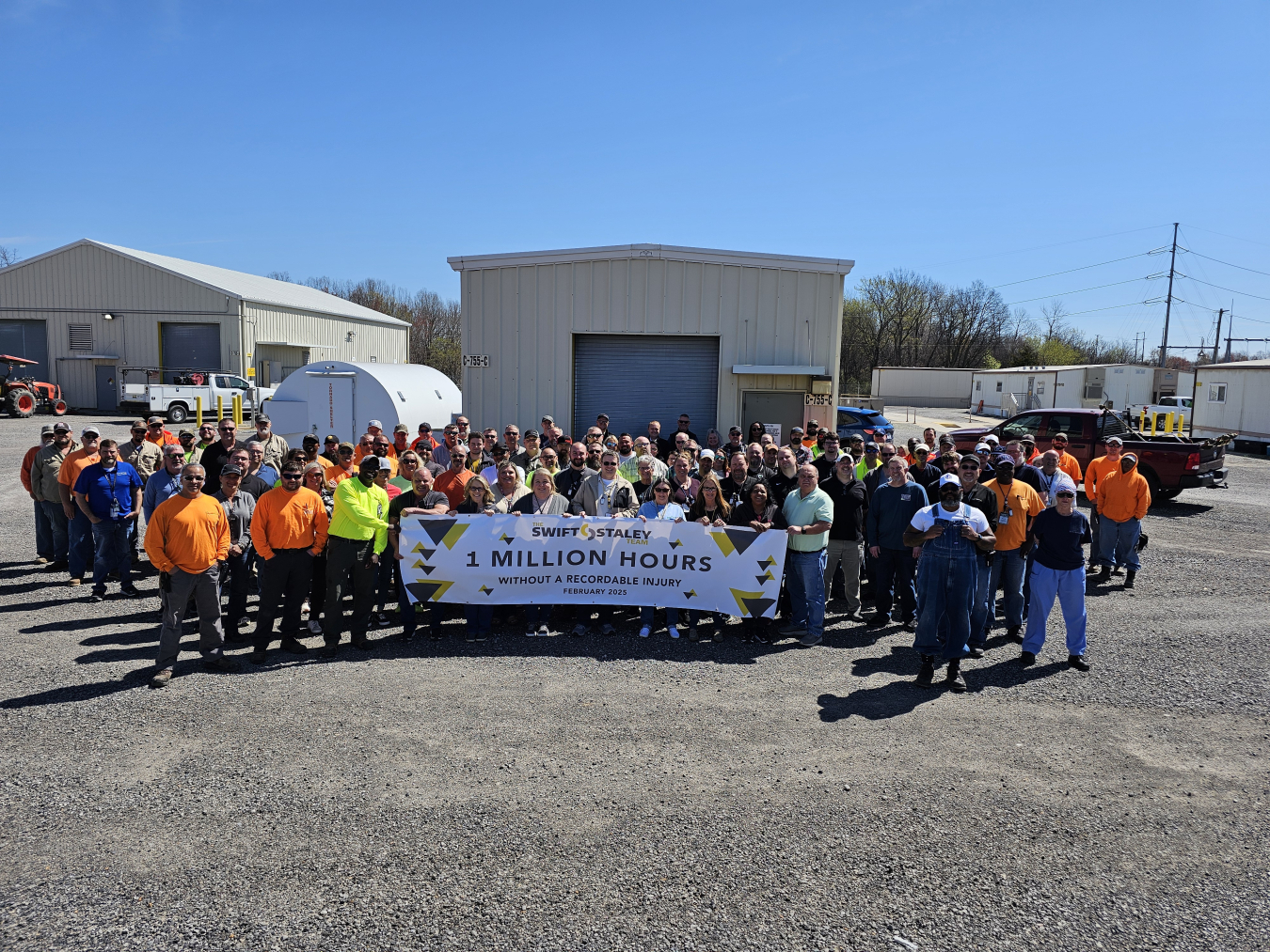 A large group of people posing for a group photo while holding a banner that says "1 million hours"