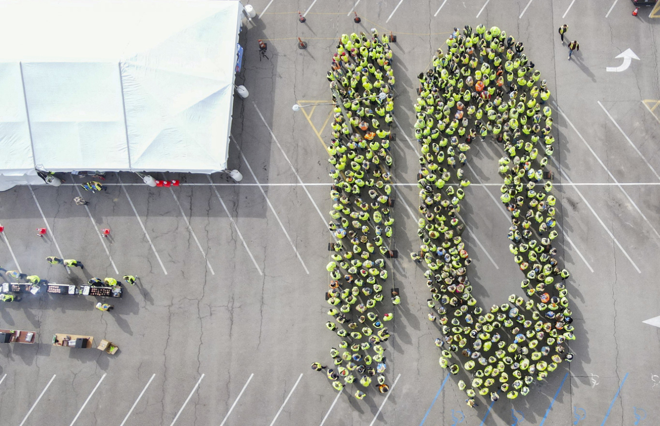 A large group of employees spelling out the number "10" with their bodies